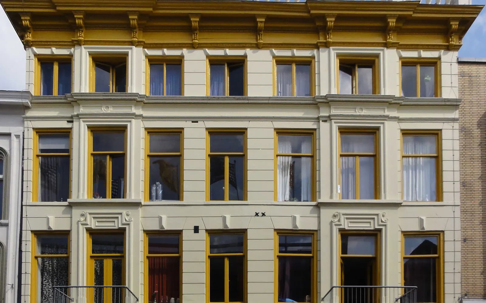 Klassieke gevel met gele kozijnen aan de Herenstraat in Groningen